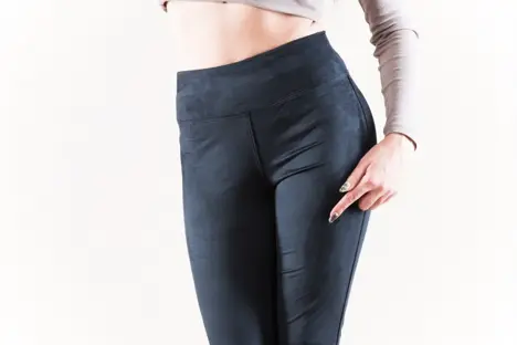 Person wearing high-waisted ostomy-friendly pants with a smooth, flat profile over the pouch area
