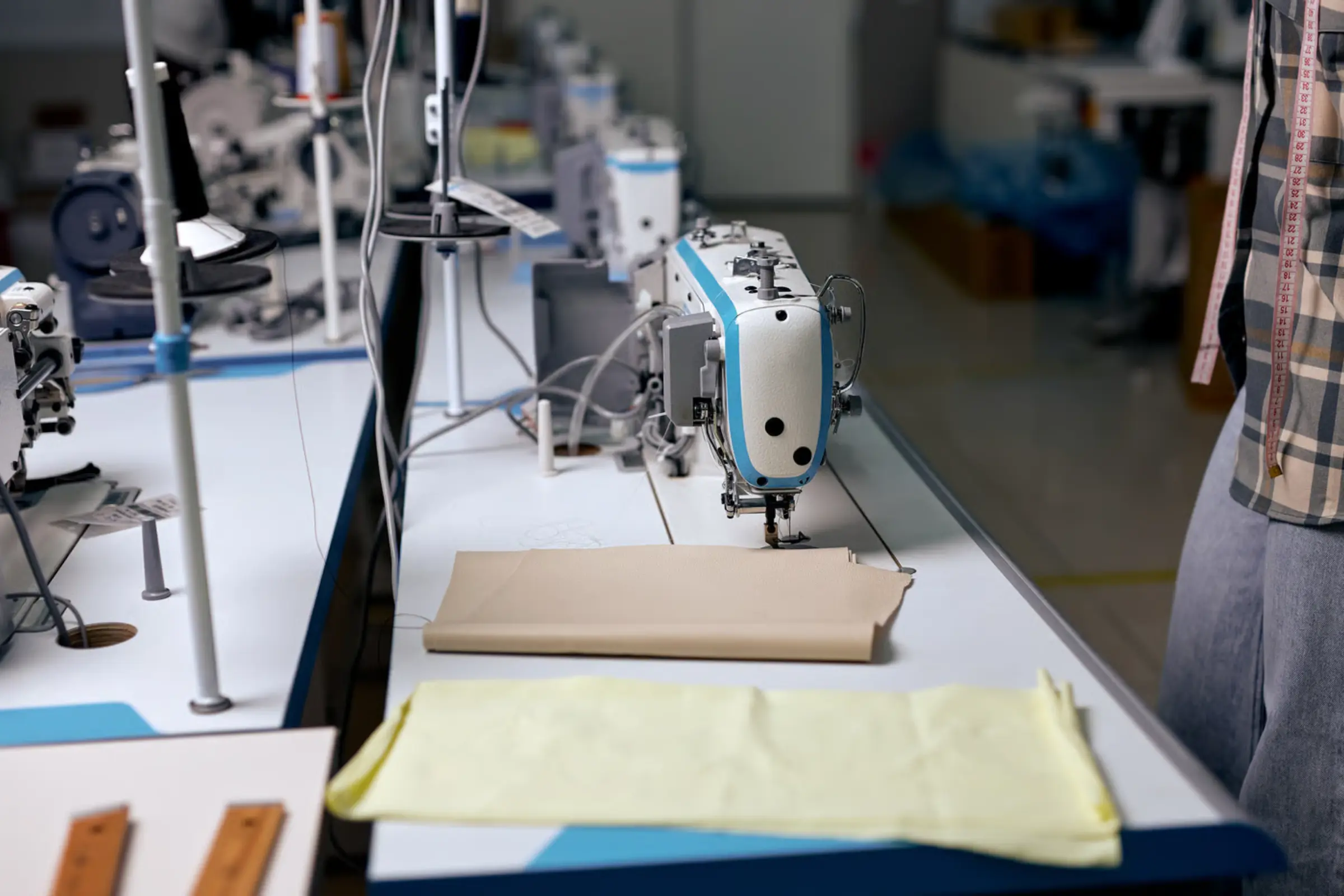 Sewing technician constructing a magnetic-closure adaptive garment in a specialized factory