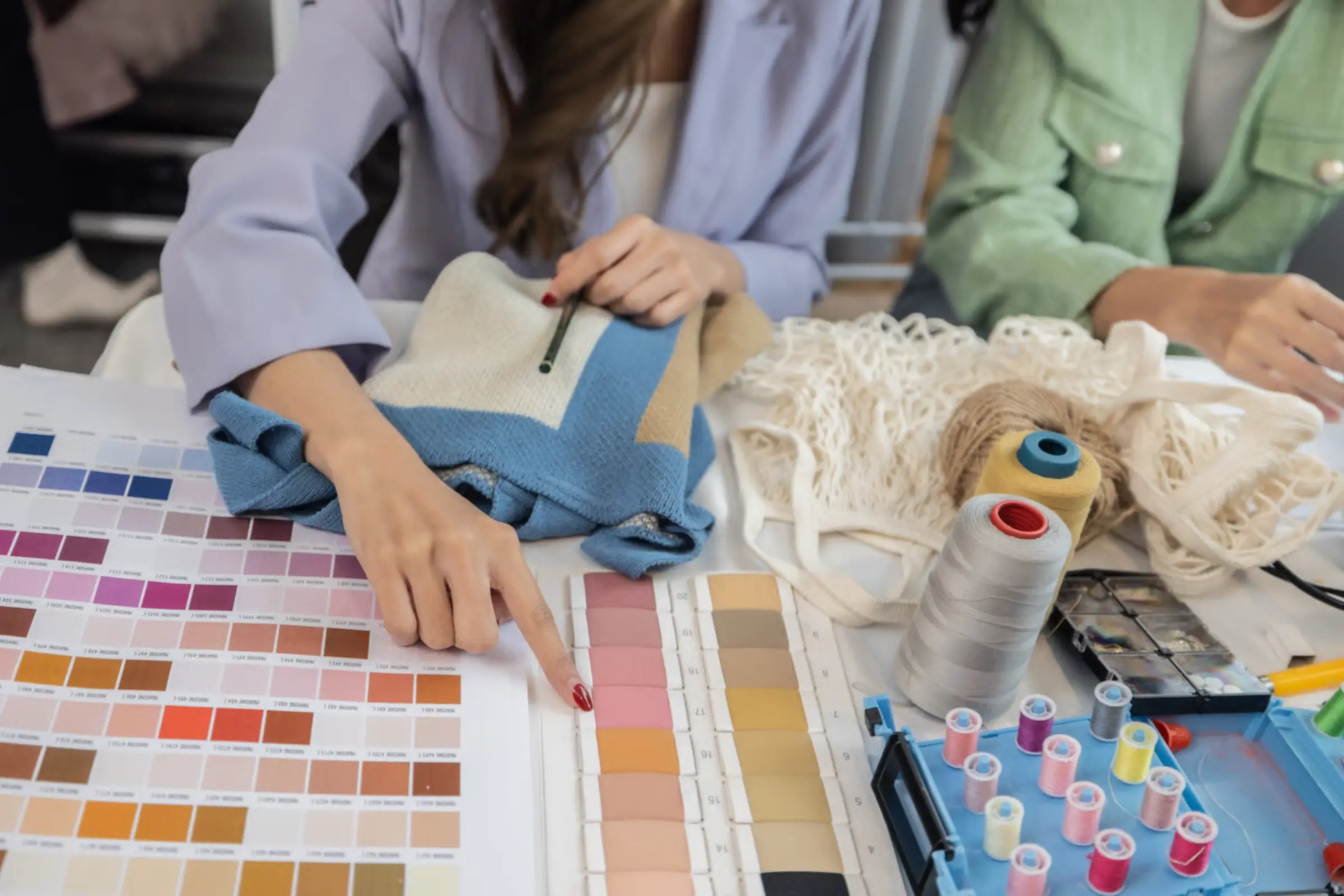 Brand representative reviewing tech pack and fabric swatches with an OEM clothing manufacturer